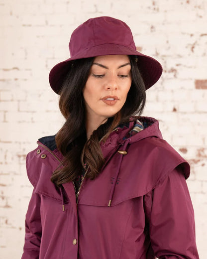 Plum coloured Lighthouse Storm Waterproof Hat on wall background 