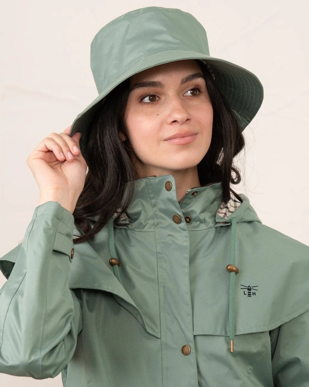 Sage coloured Lighthouse Storm Waterproof Hat on wall background 