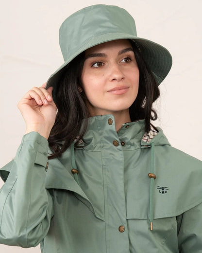 Sage coloured Lighthouse Storm Waterproof Hat on wall background 