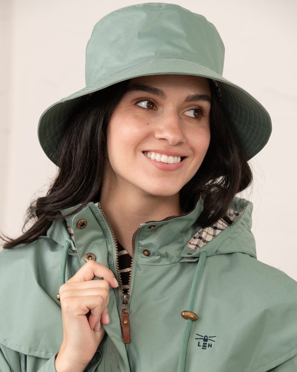 Sage coloured Lighthouse Storm Waterproof Hat on wall background 