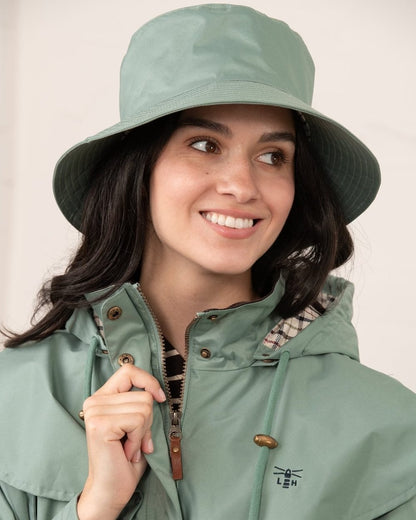 Sage coloured Lighthouse Storm Waterproof Hat on wall background 