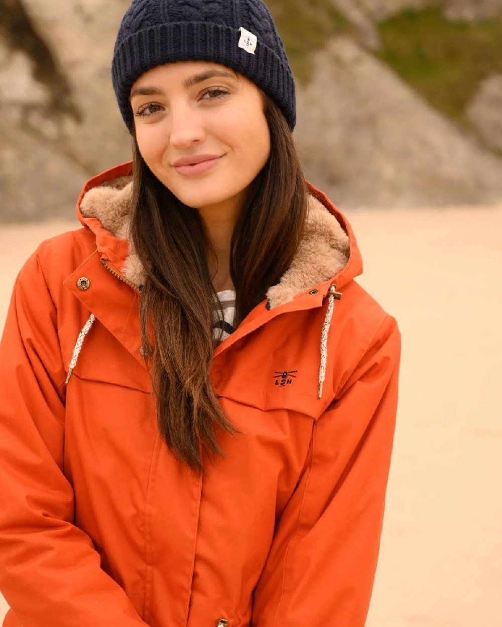 Burnt Orange coloured Lighthouse Isobel Ladies Coat on beach background 
