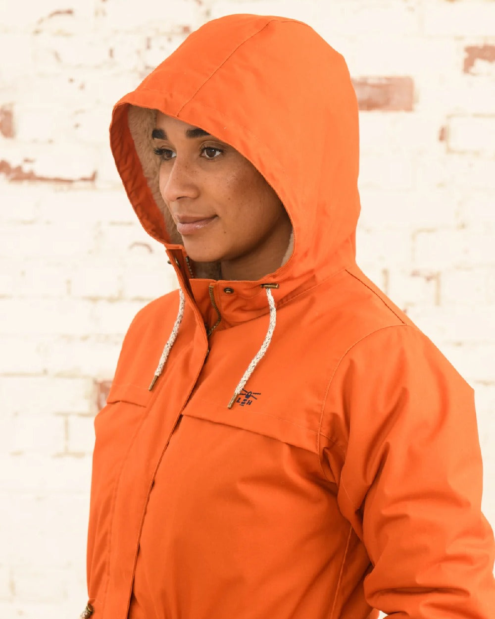 Burnt Orange coloured Lighthouse Isobel Ladies Coat on wall background 