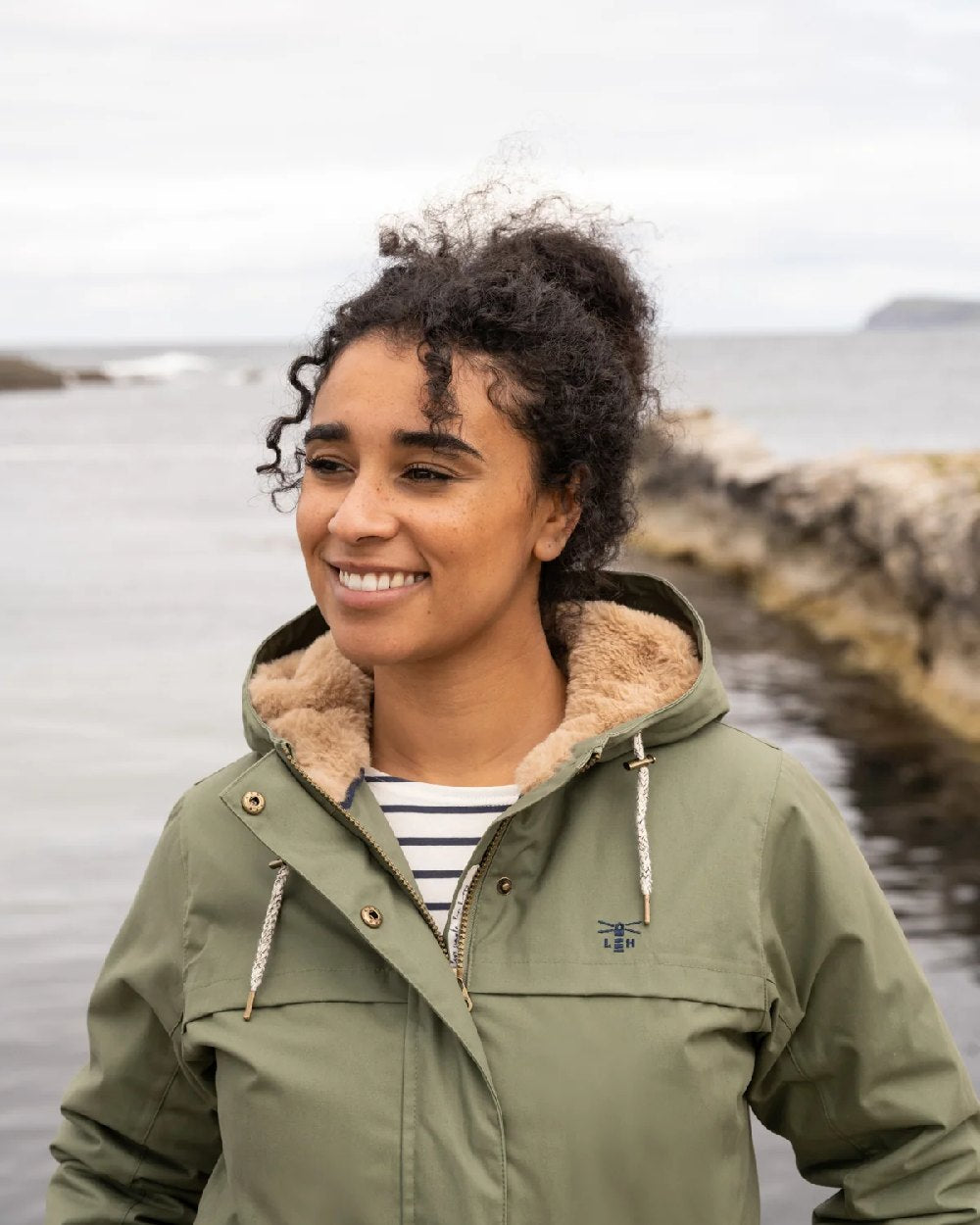 Khaki coloured Lighthouse Isobel Ladies Coat on sea background 