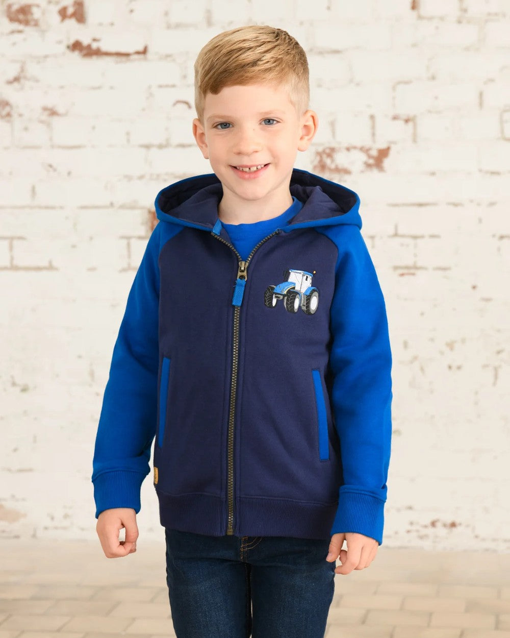 Blue Tractor coloured Lighthouse Jackson Childrens Full Zip Hoodie on wall background 