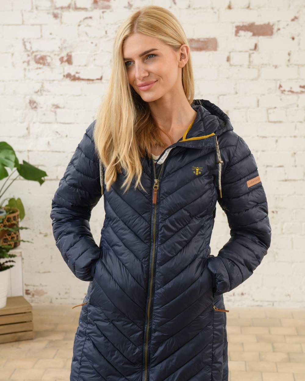 Navy coloured Lighthouse Laurel Ladies Coat on wall background 