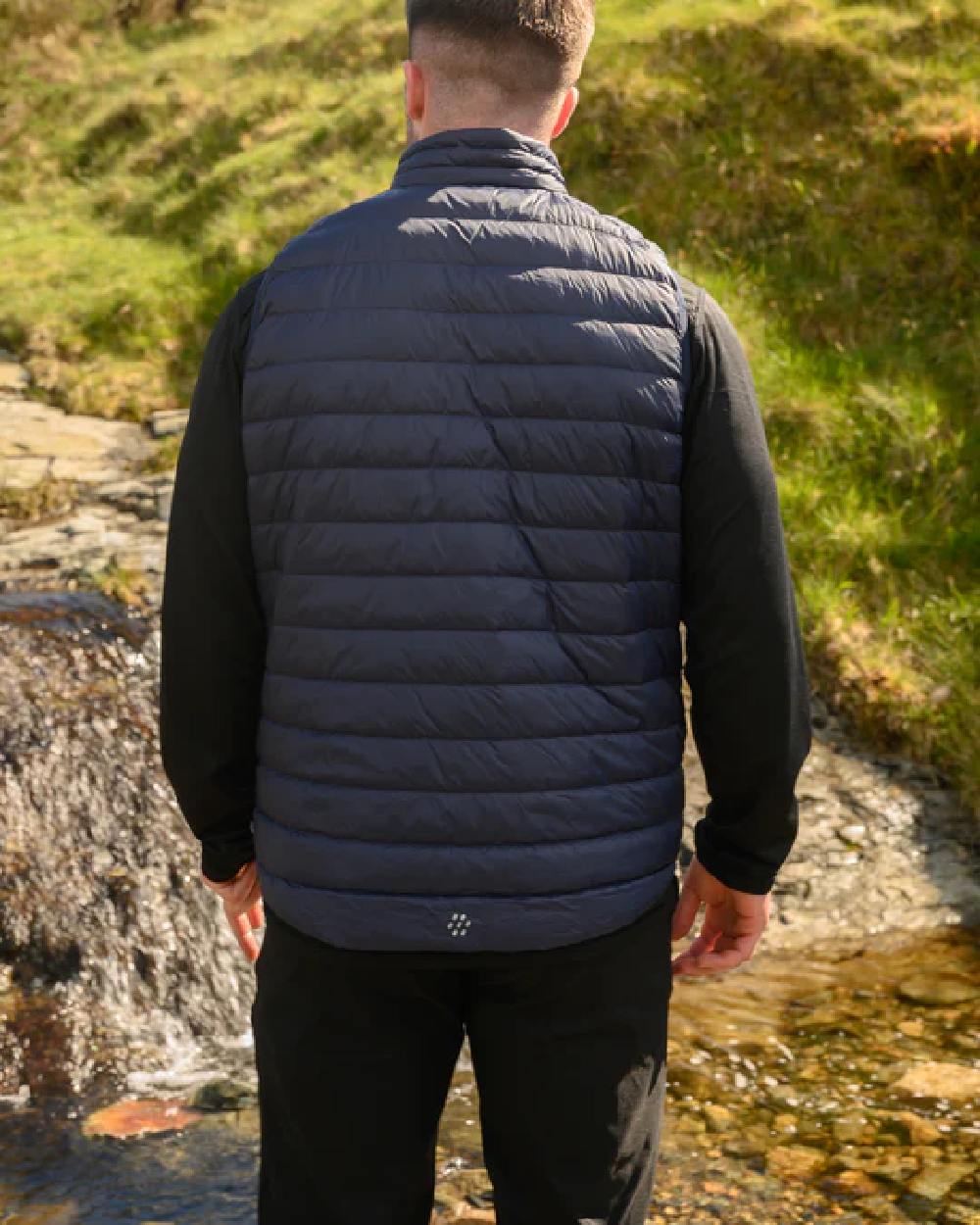 Navy coloured Mac In A Sac Mens Alpine Down Gilet on blurry mountain background 