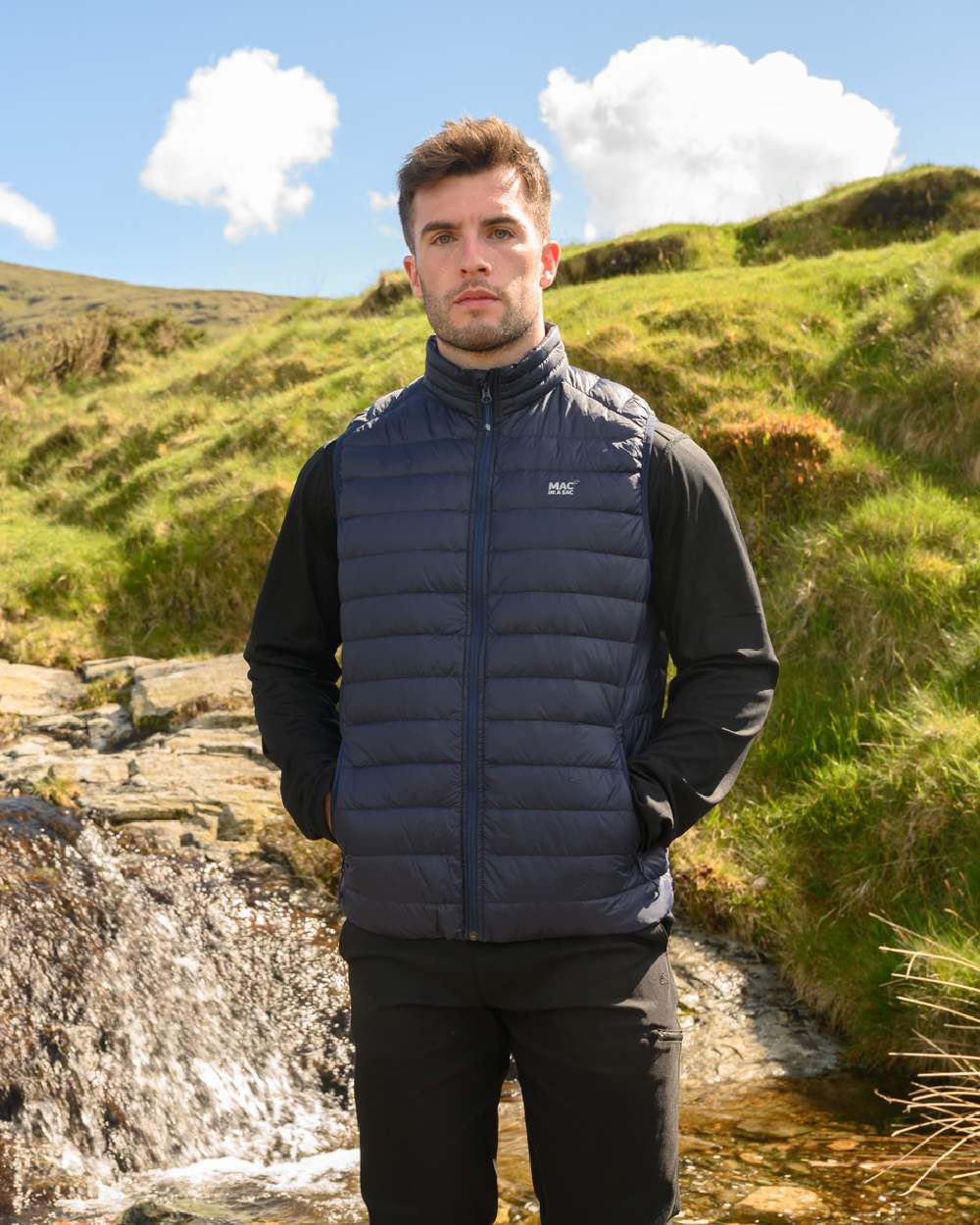 Navy Coloured Mac In A Sac Mens Alpine Down Gilet on mountain background 