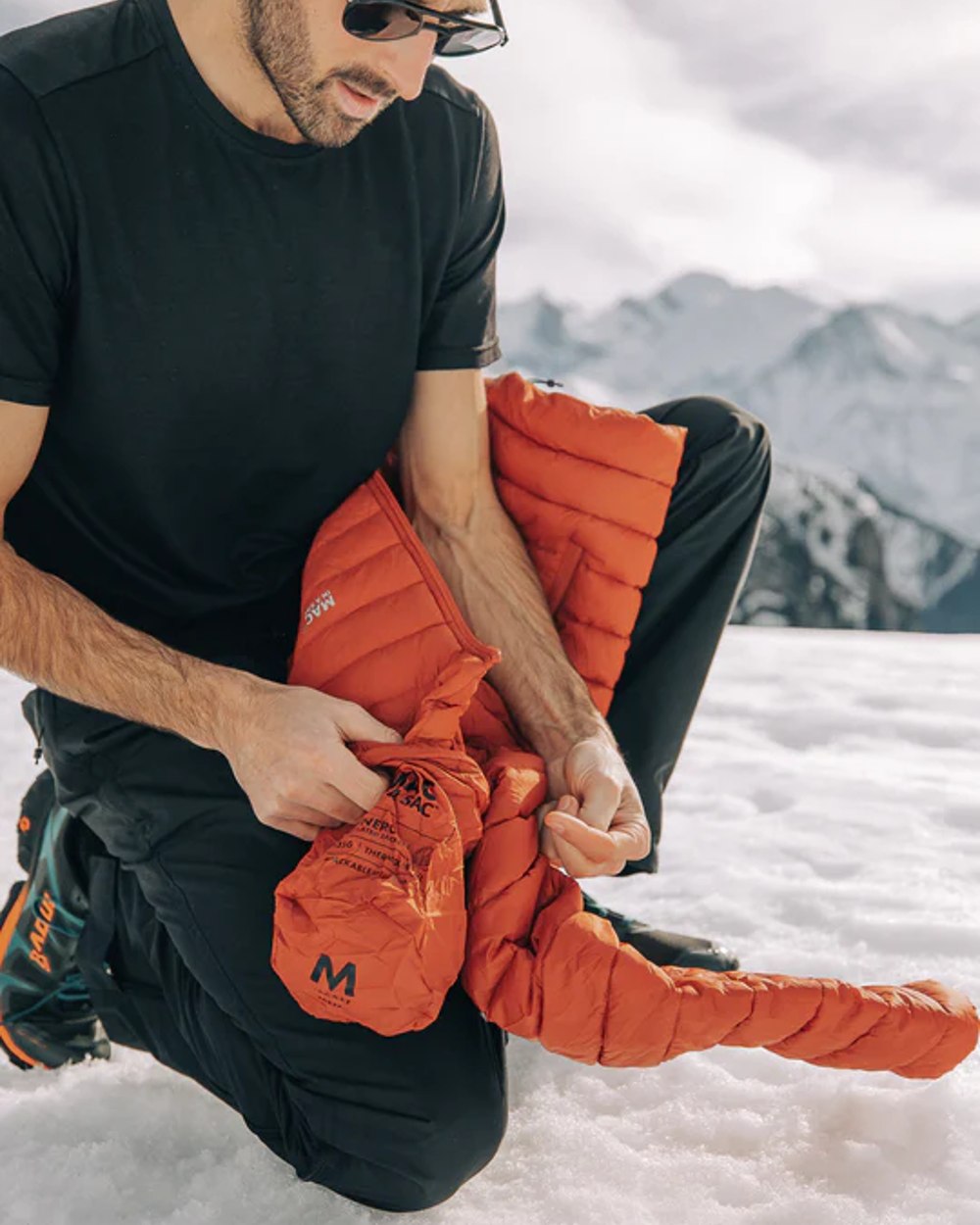 Burnt Orange coloured Mac In A Sac Mens Synergy Jacket on snow background 