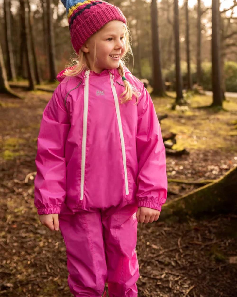 Pink coloured Mac In A Sac Origin 2 Puddlesuit on blurry background 