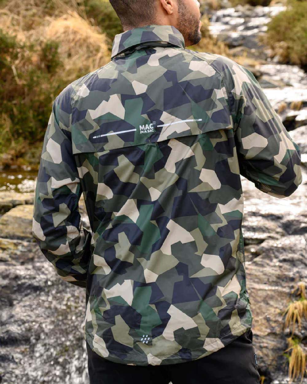 Green Camo Coloured Mac In A Sac Origin Camo Packable Waterproof Jacket on blurry background 