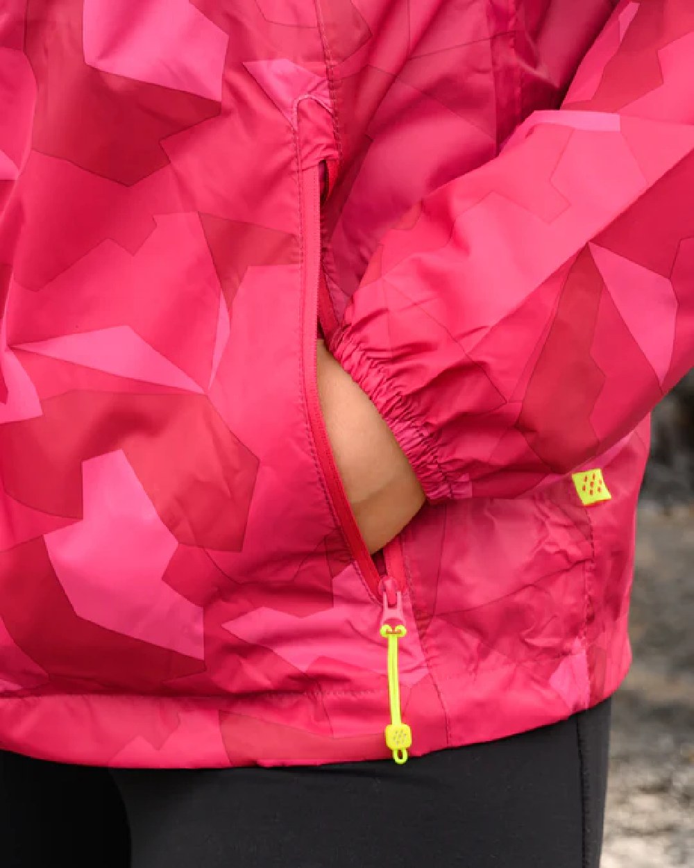 Pink Camo Coloured Mac In A Sac Origin Camo Packable Waterproof Jacket on blurry background 