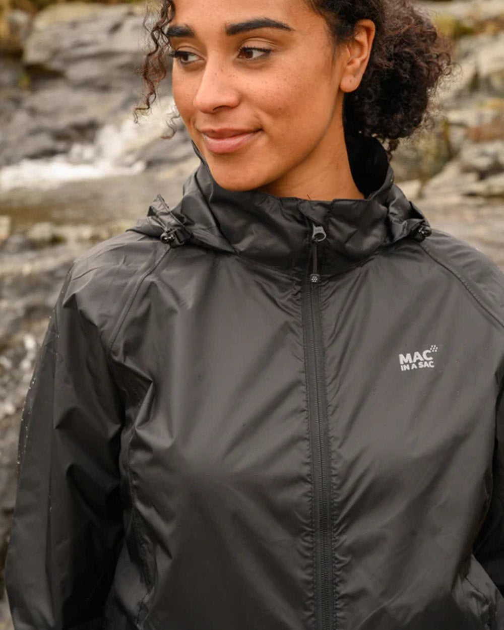 Jet Black coloured Mac In A Sac Packable Origin Waterproof Jacket on outdoor background 