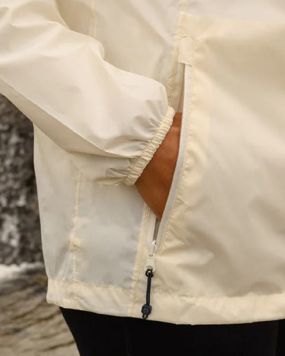 Ivory coloured Mac In A Sac Packable Origin Waterproof Jacket on outdoor background 