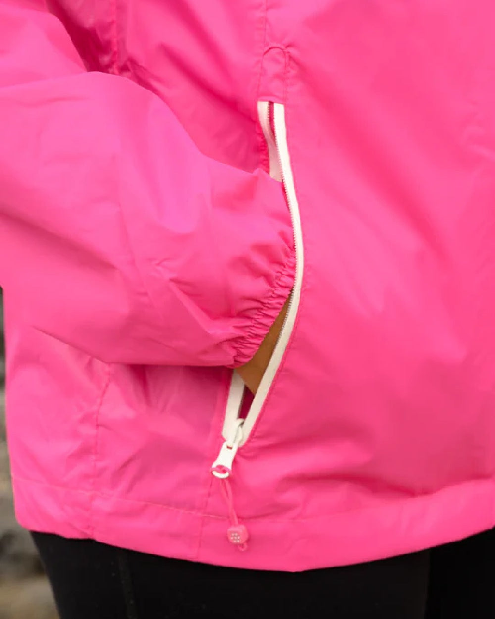 Pink Coloured Mac In A Sac Origin Packable Waterproof Jacket on blurry background 