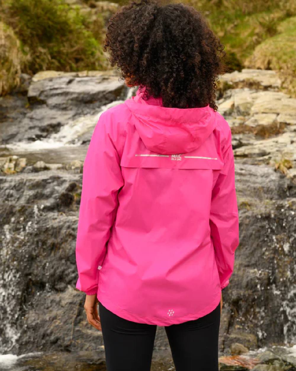 Pink Coloured Mac In A Sac Origin Packable Waterproof Jacket on waterfall background 