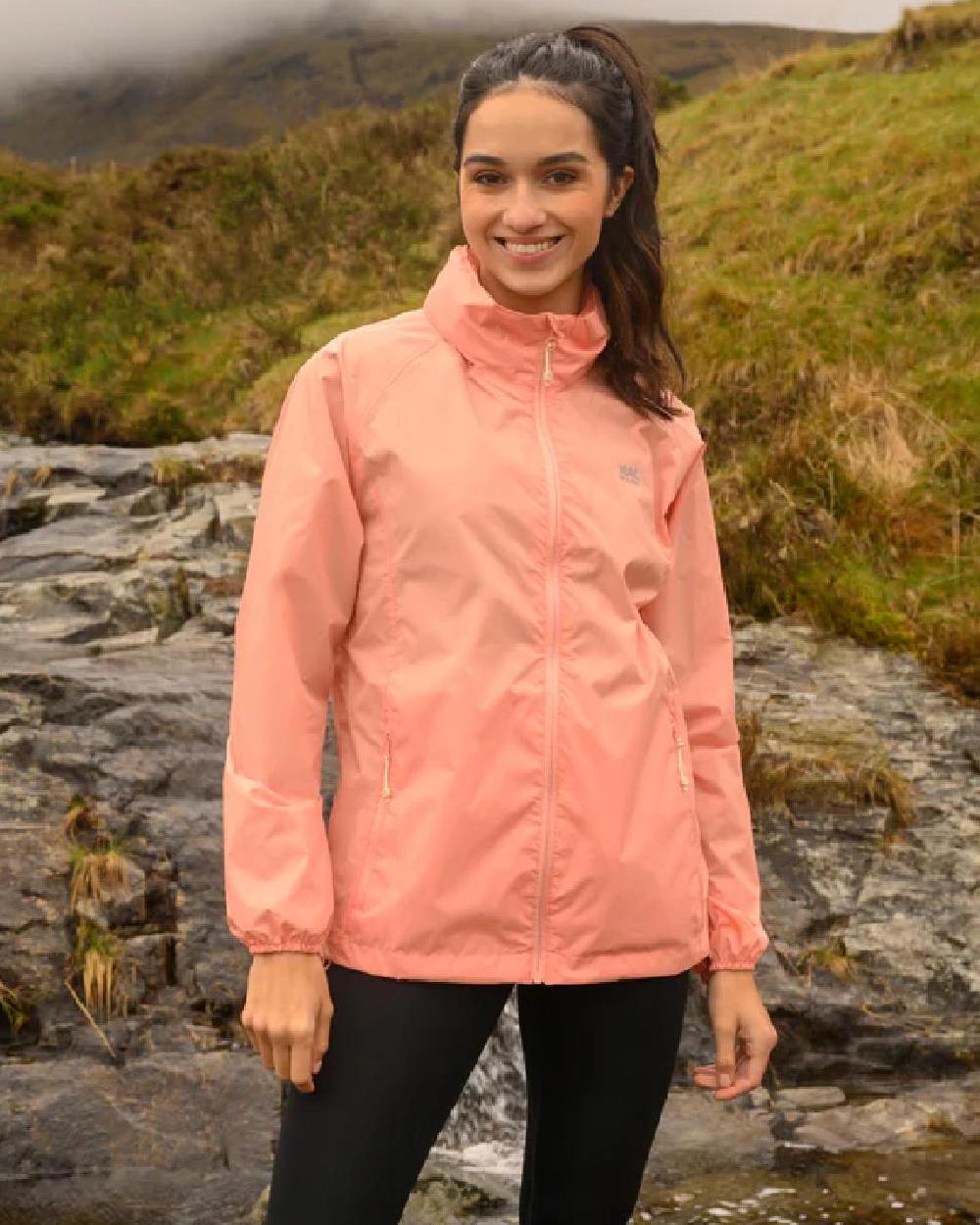 Soft Coral coloured Mac In A Sac Packable Origin Waterproof Jacket on outdoor background 