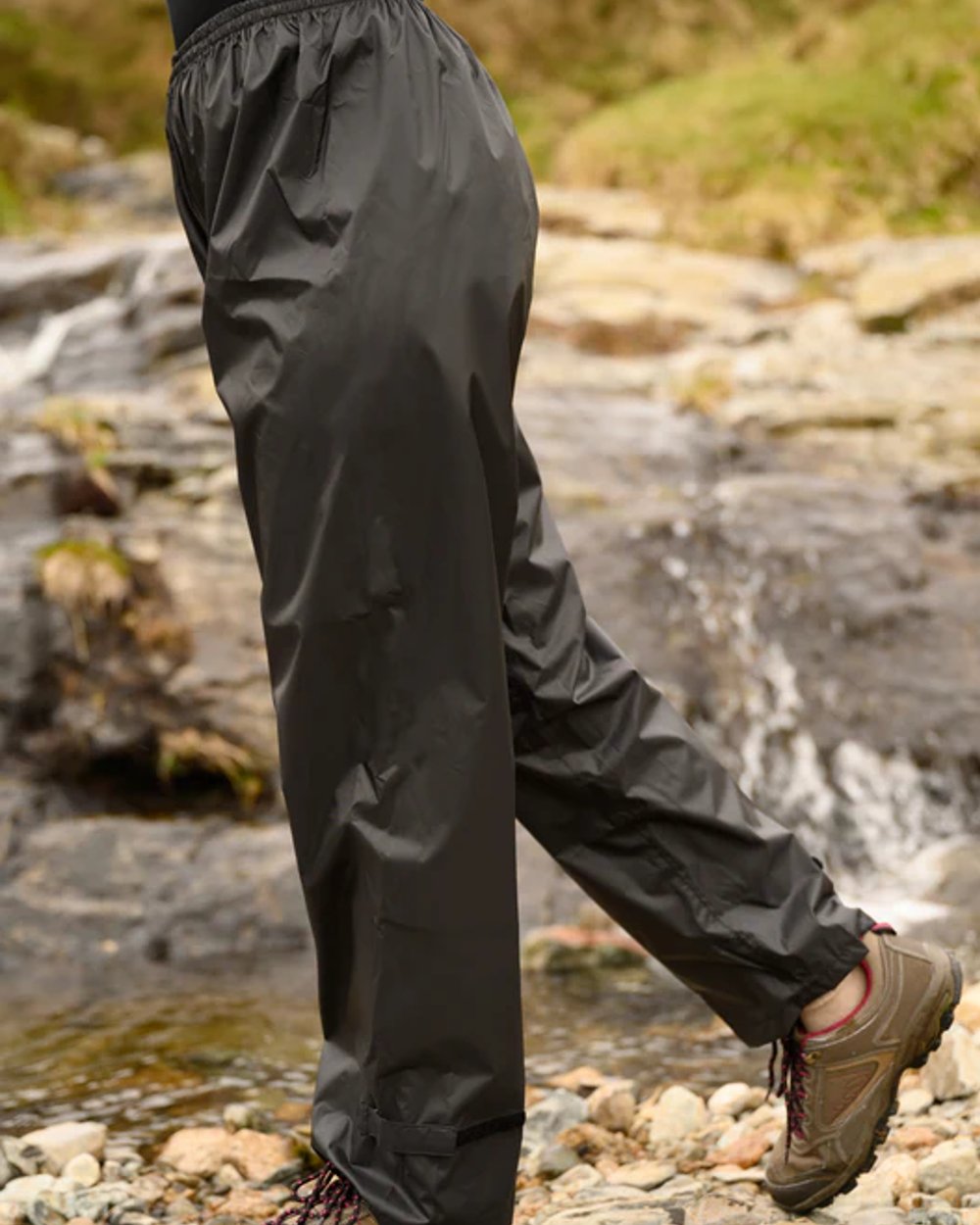 Black coloured Mac In A Sac Origin Packable Waterproof Overtrousers on blurry background 