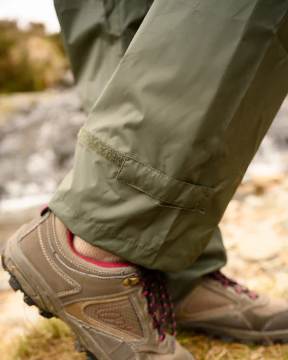 khaki coloured Mac In A Sac Origin Packable Waterproof Overtrousers on blurry background 