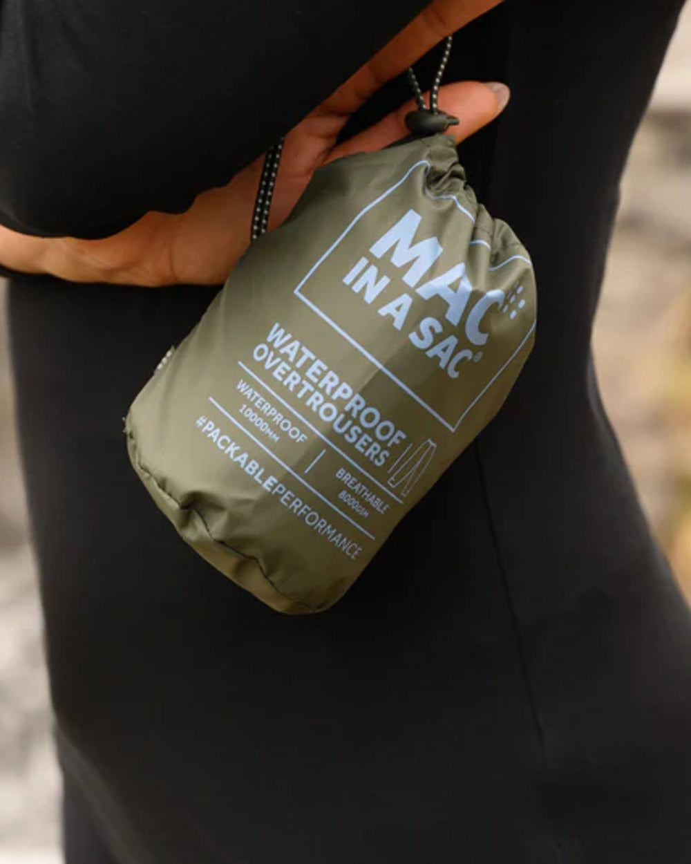 khaki coloured Mac In A Sac Origin Packable Waterproof Overtrousers on blurry  background 