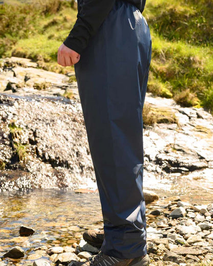 Navy coloured Mac In A Sac Origin Packable Waterproof Overtrousers on blurry background 