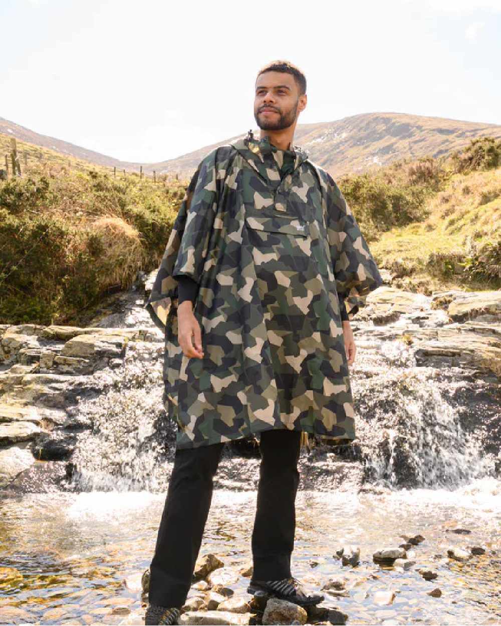 Green Camo Coloured Mac In A Sac Origin Waterproof Poncho on mountain background 