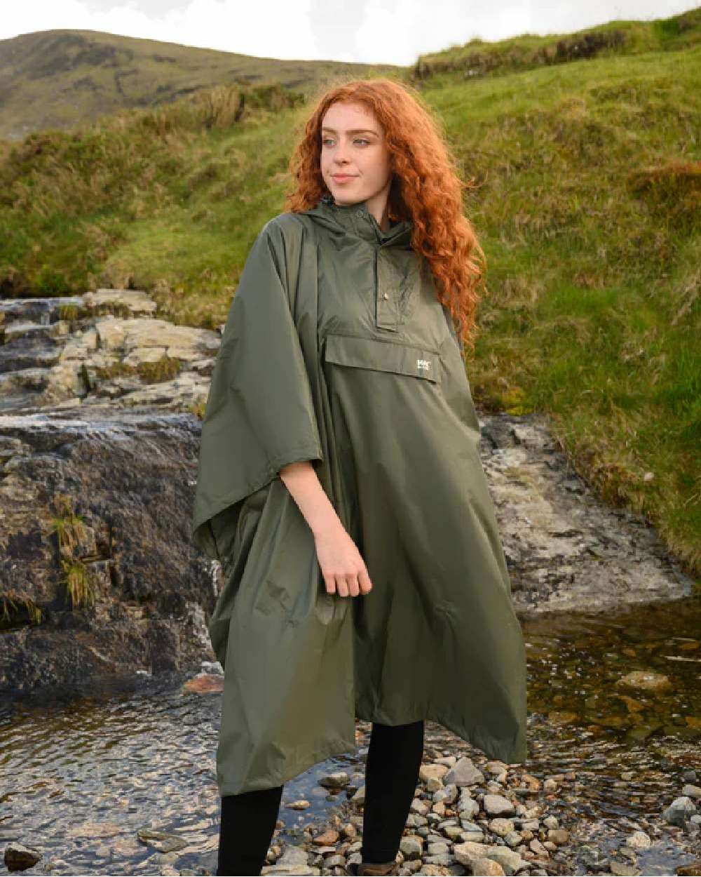 Khaki Coloured Mac In A Sac Origin Waterproof Poncho on mountain background 