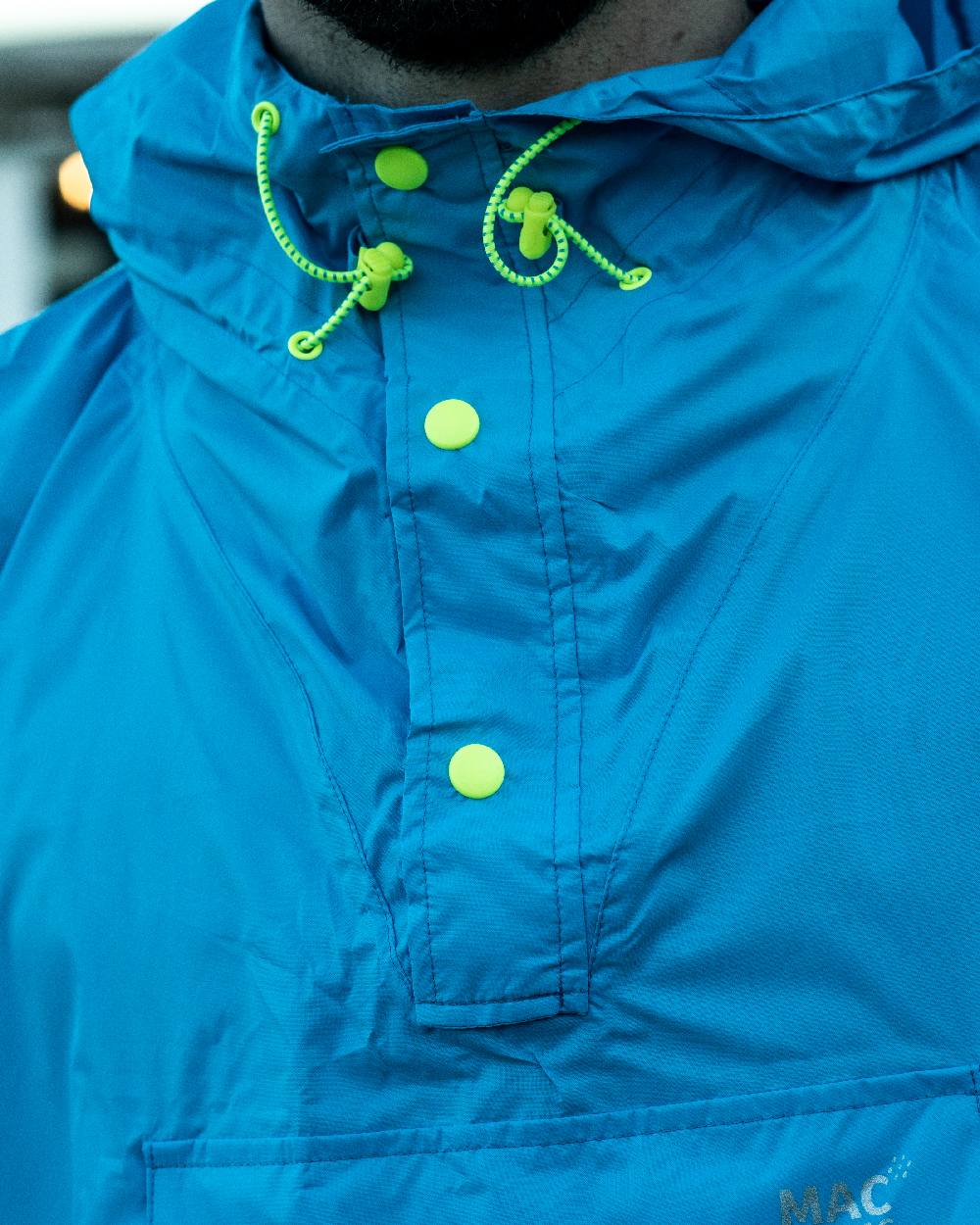 Neon Blue Coloured Mac In A Sac Origin Waterproof Poncho Neon on blurry background 
