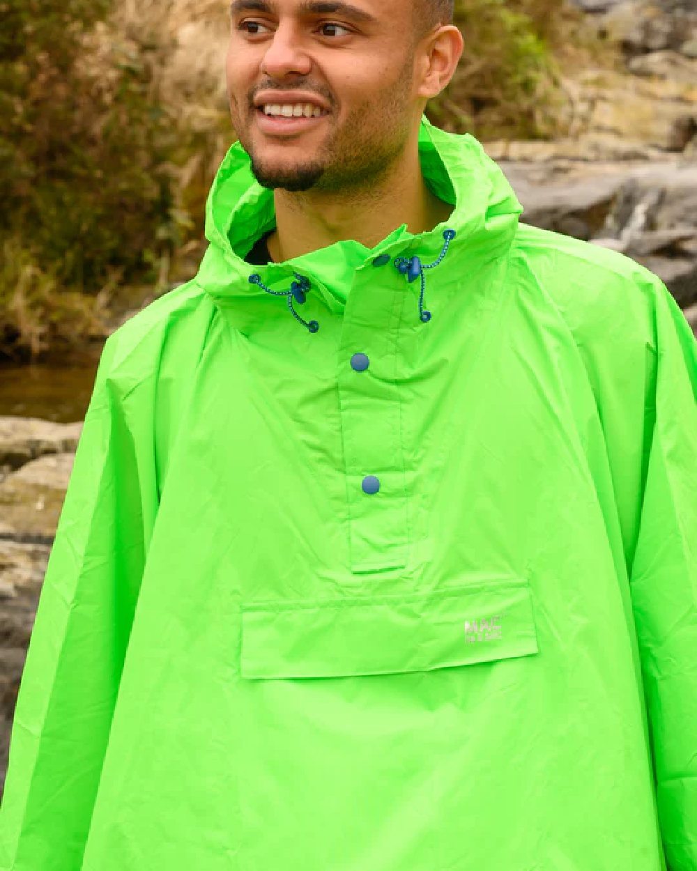 Neon Green Coloured Mac In A Sac Origin Waterproof Poncho Neon on blurry background 