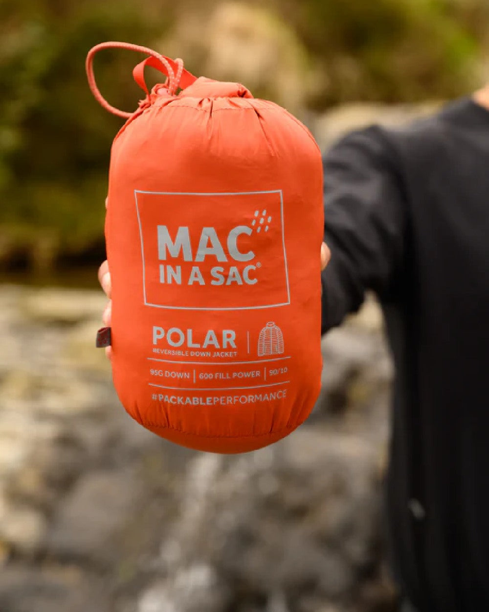 Burnt Orange Grey coloured Mac In A Sac Packable Mens Polar Down Jacket on blurry background 