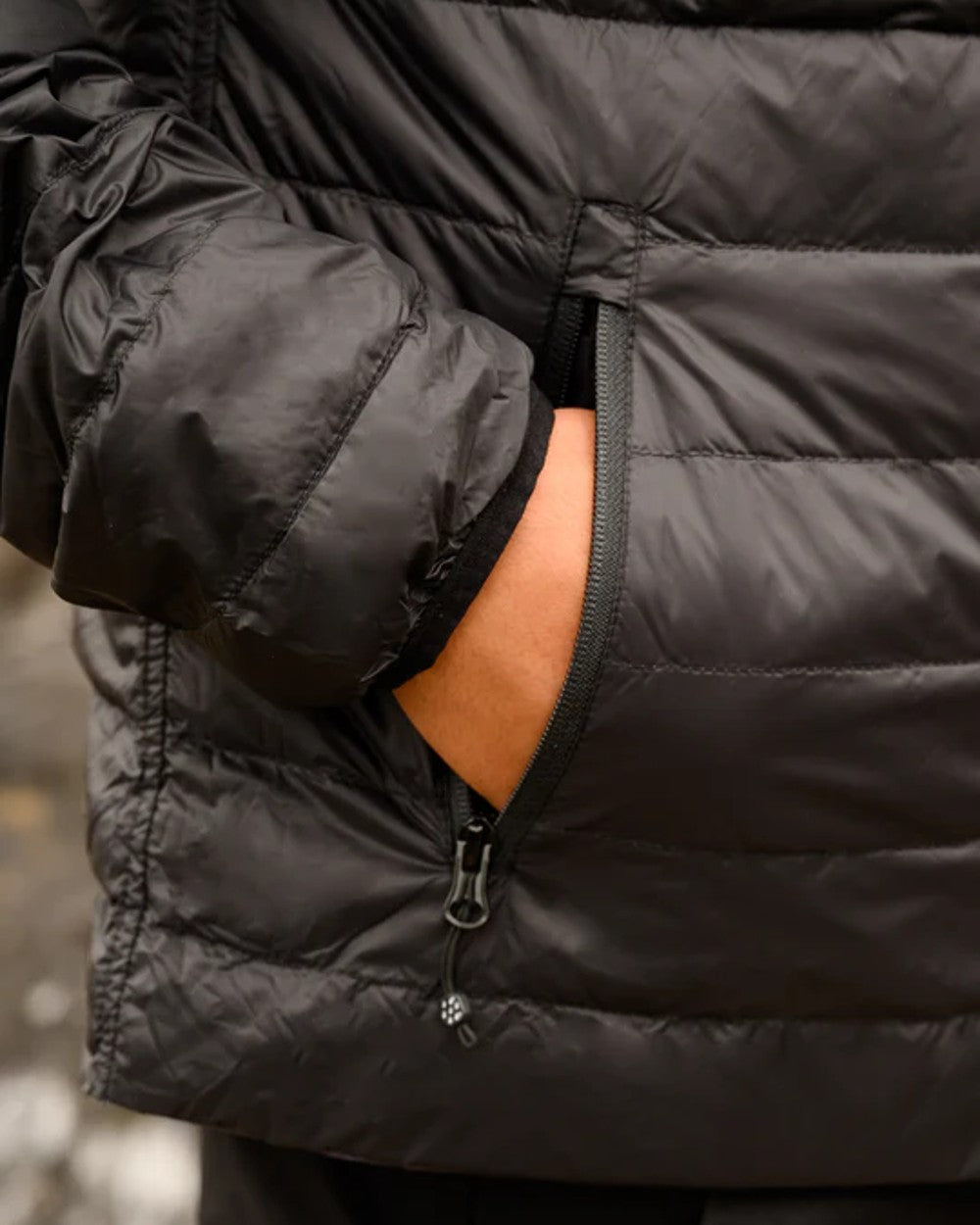 Jet Black Charcoal coloured Mac In A Sac Packable Mens Polar Down Jacket on blurry background 