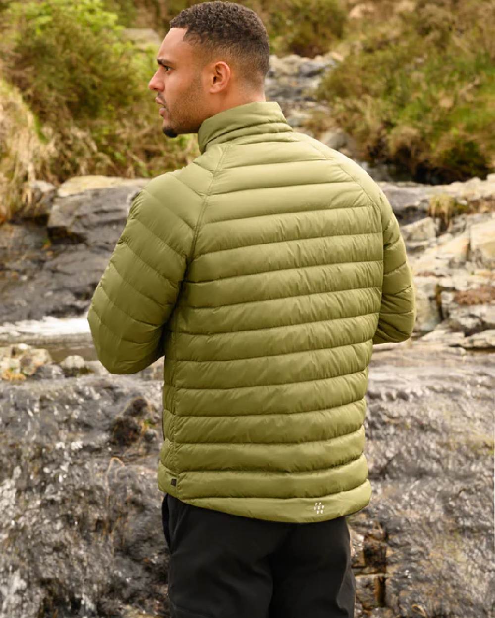Khaki Black coloured Mac In A Sac Packable Mens Polar Down Jacket on blurry green background 