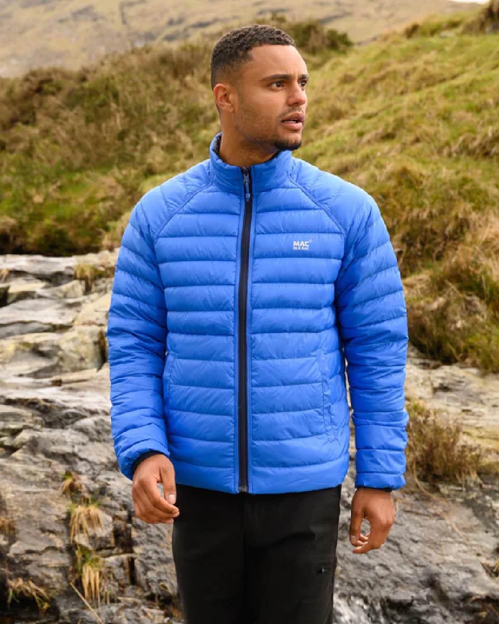 Navy Saxe Blue coloured Mac In A Sac Packable Mens Polar Down Jacket on blurry green background 