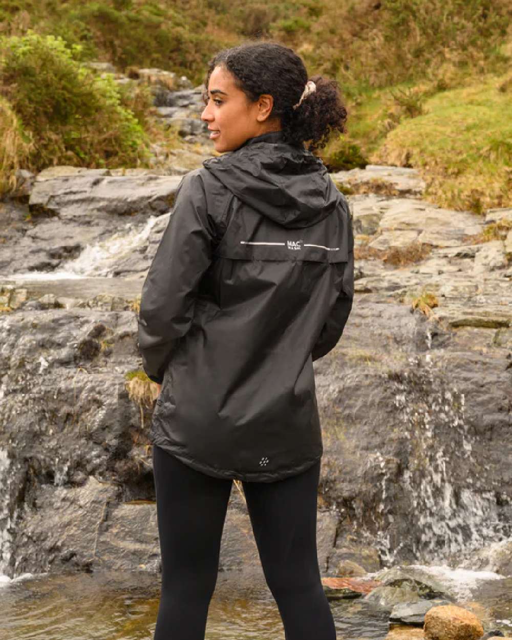 Jet Black coloured Mac In A Sac Packable Origin Waterproof Jacket on blurry background 