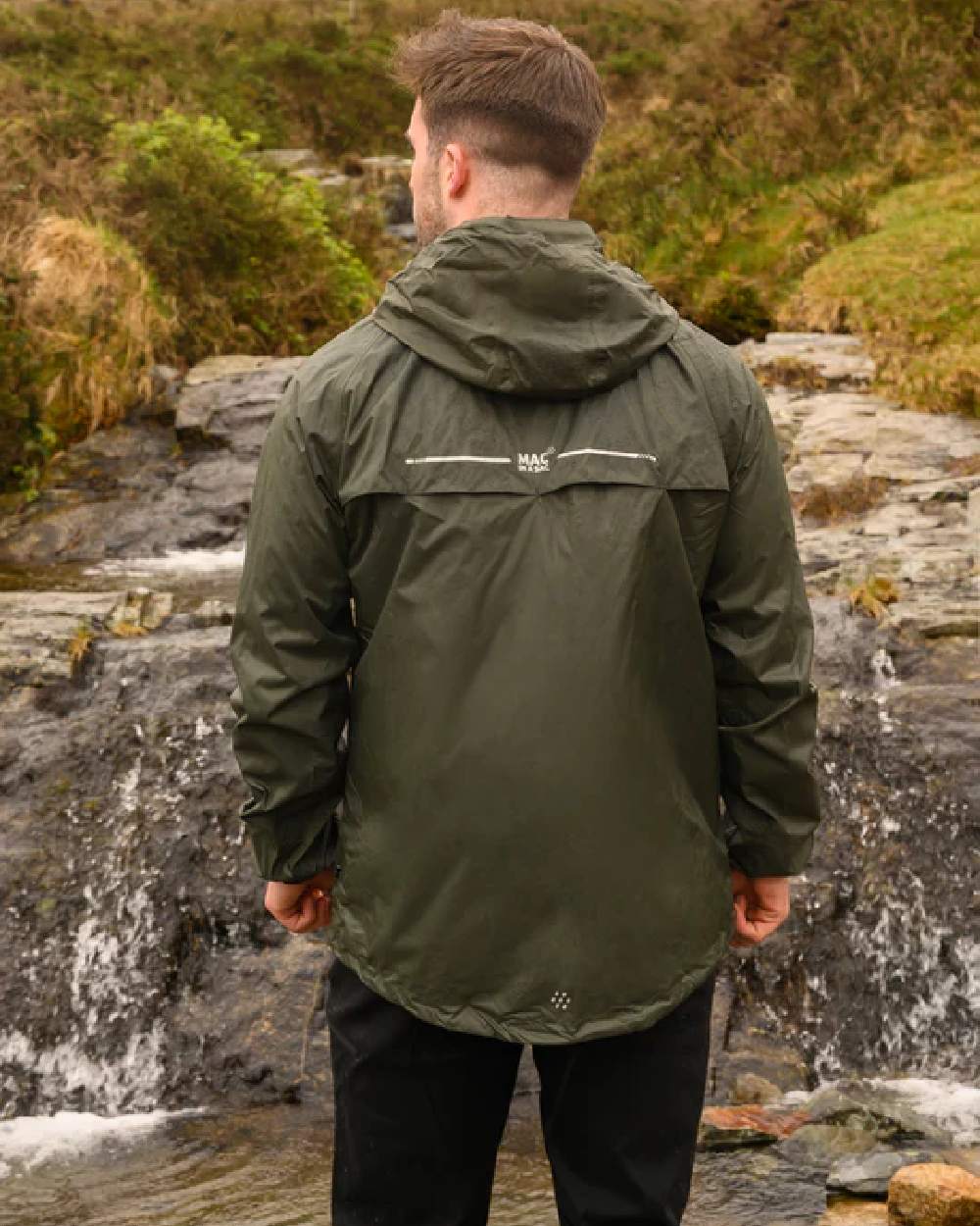 Khaki coloured Mac In A Sac Packable Origin Waterproof Jacket on blurry background 