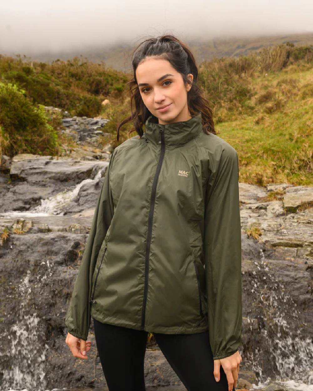 Khaki coloured Mac In A Sac Packable Origin Waterproof Jacket on blurry background 