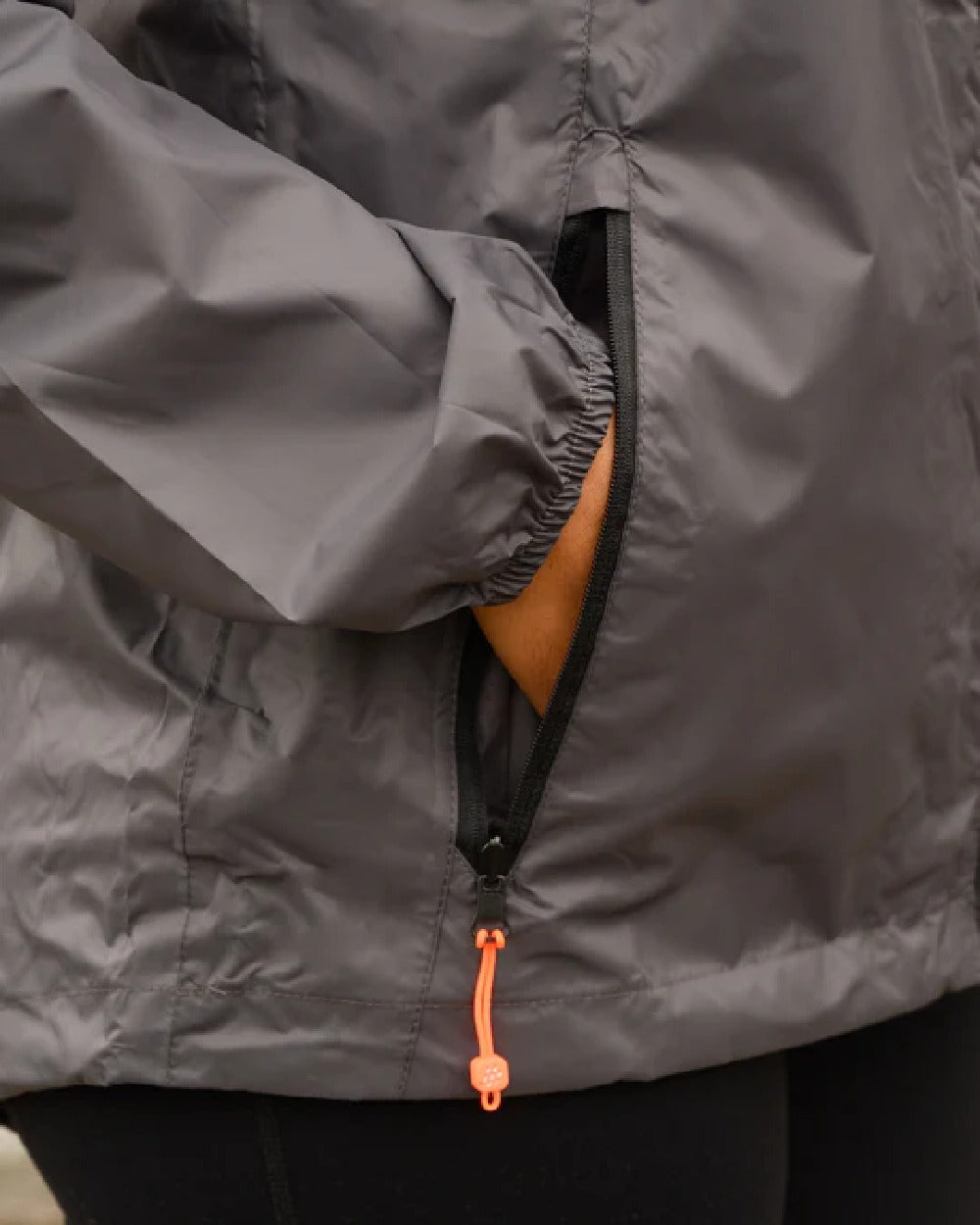 Charcoal coloured Mac In A Sac Packable Origin Waterproof Jacket on blurry background 