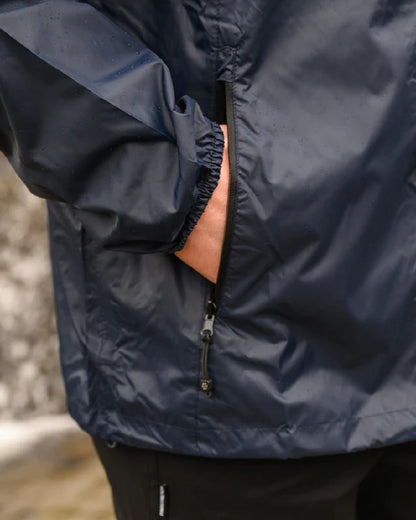 Navy coloured Mac In A Sac Packable Origin Waterproof Jacket on blurry background 