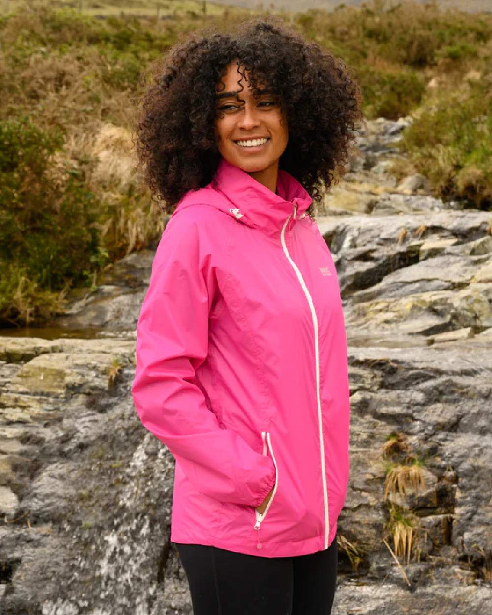 Pink coloured Mac In A Sac Packable Origin Waterproof Jacket on blurry background 