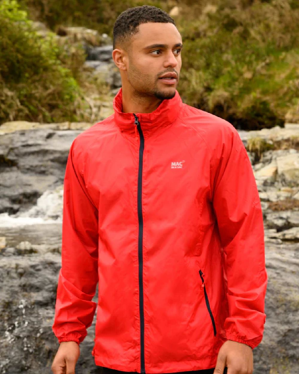 Red coloured Mac In A Sac Packable Origin Waterproof Jacket on blurry background 