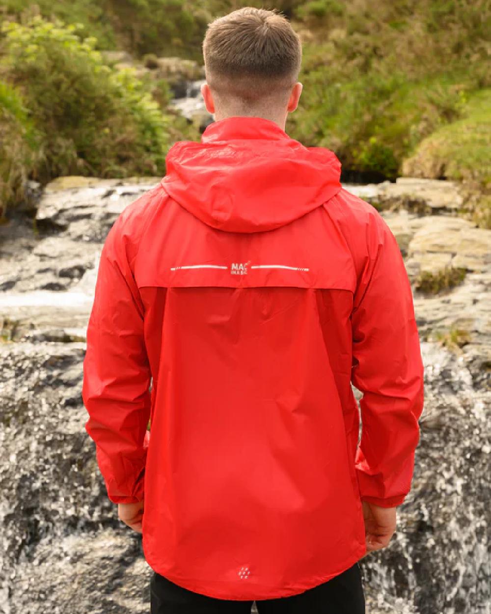 Red coloured Mac In A Sac Packable Origin Waterproof Jacket on blurry background 