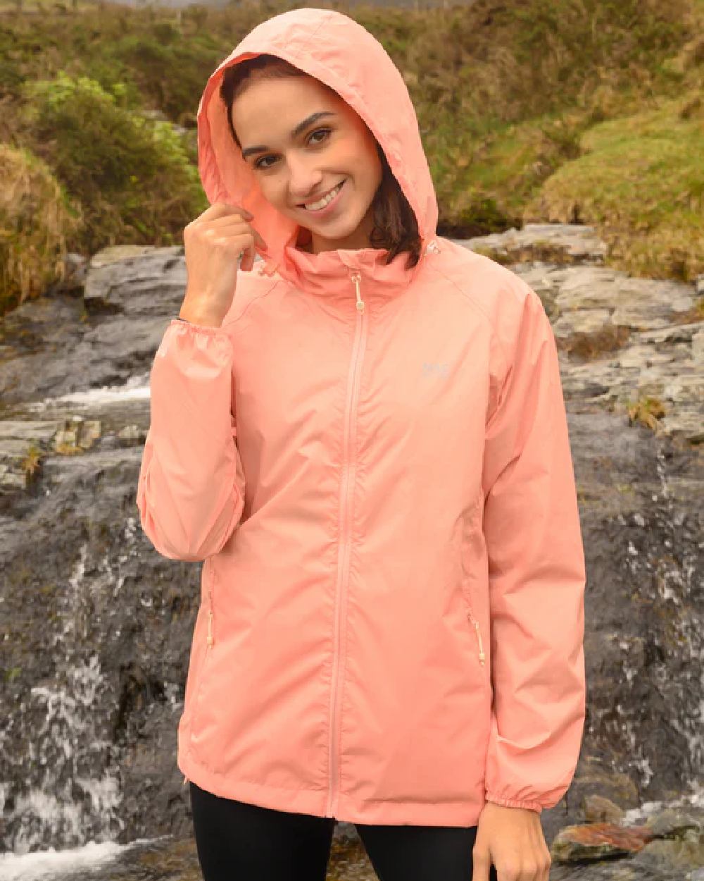Soft Coral coloured Mac In A Sac Packable Origin Waterproof Jacket on blurry background 