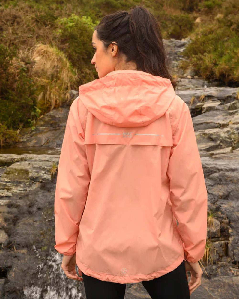 Soft Coral coloured Mac In A Sac Packable Origin Waterproof Jacket on blurry background 