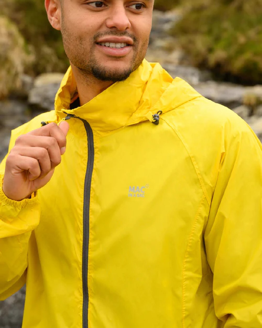 Yellow coloured Mac In A Sac Packable Origin Waterproof Jacket on blurry background 