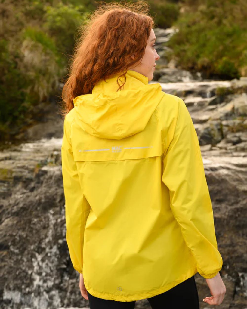 Yellow coloured Mac In A Sac Packable Origin Waterproof Jacket on blurry background 