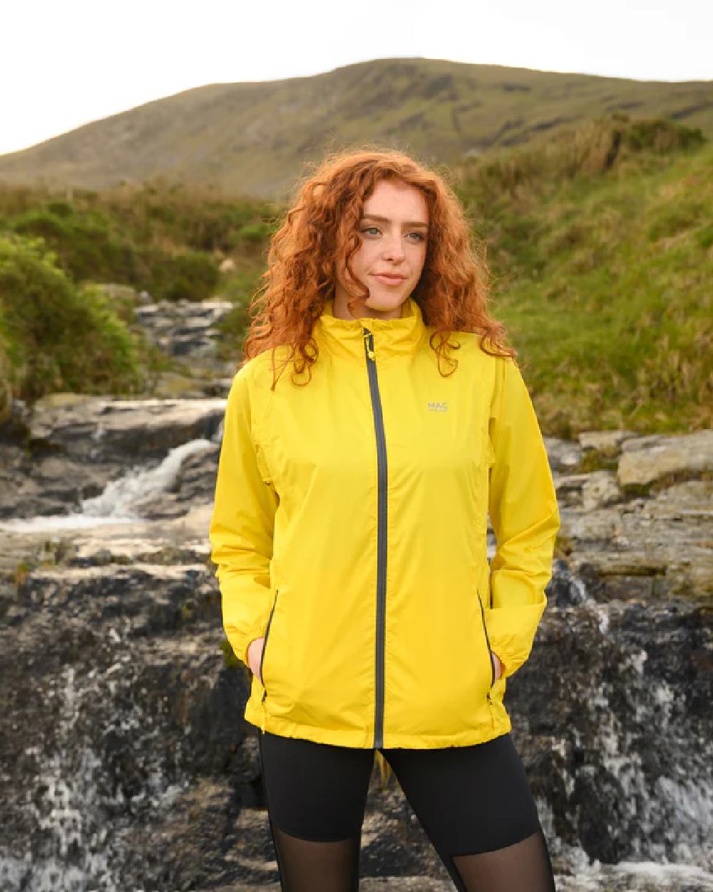 Yellow coloured Mac In A Sac Packable Origin Waterproof Jacket on blurry background 