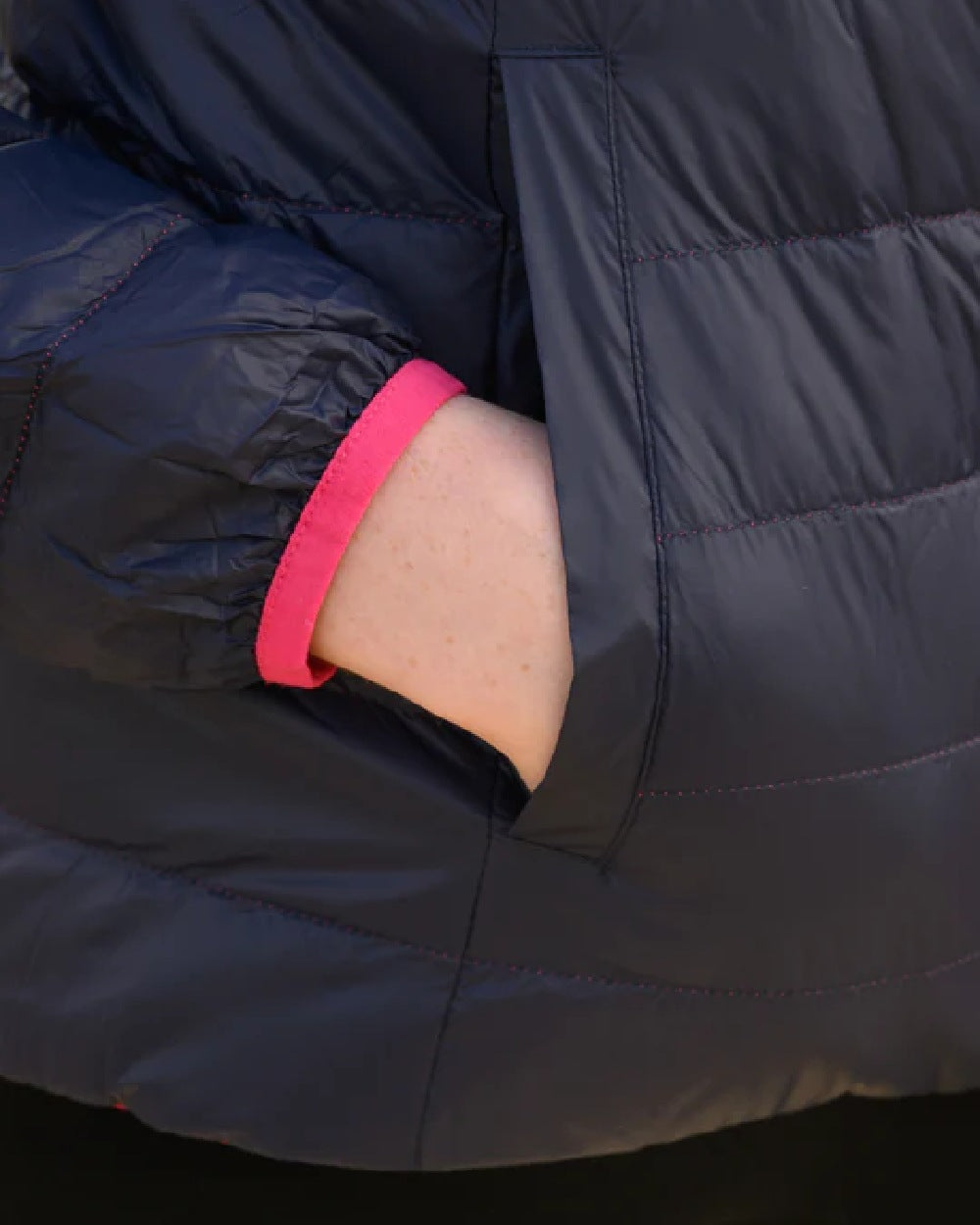 Fuchsia Navy coloured Mac In A Sac Packable Womens Down Jacket on blurry background 