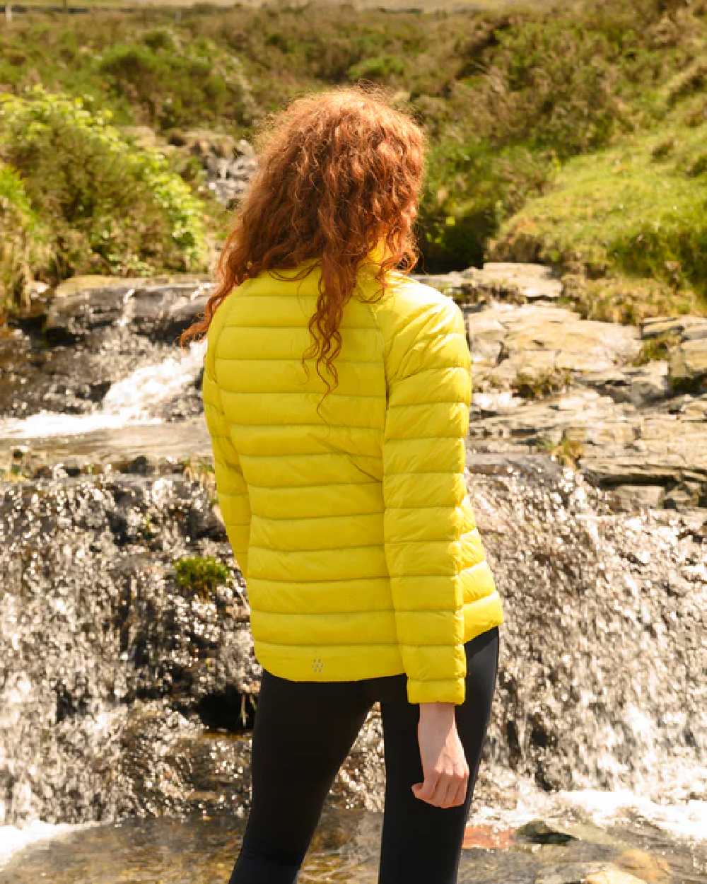 Yellow Grape coloured Mac In A Sac Packable Womens Down Jacket on blurry background 