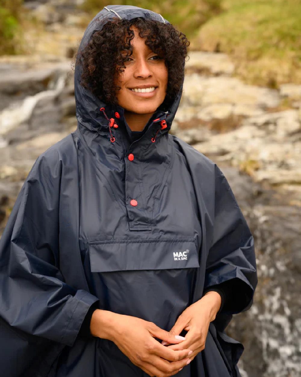 Navy coloured Mac In A Sac Waterproof Poncho on a blurry background 