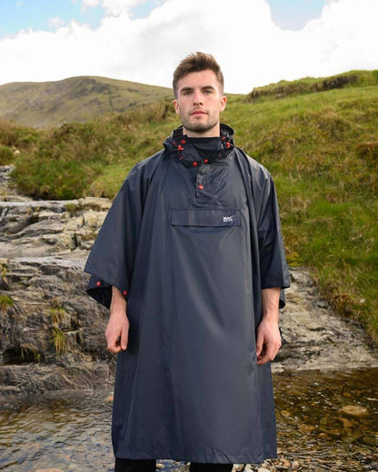 Navy coloured Mac In A Sac Waterproof Poncho on a mountain background 